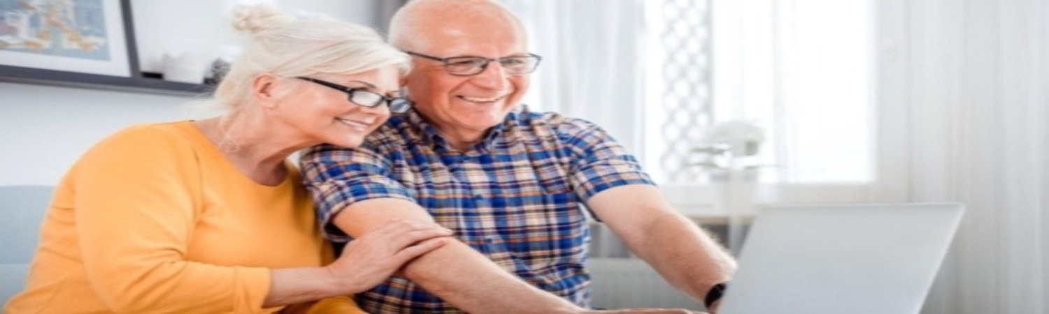 an elderly couple viewing their laptop